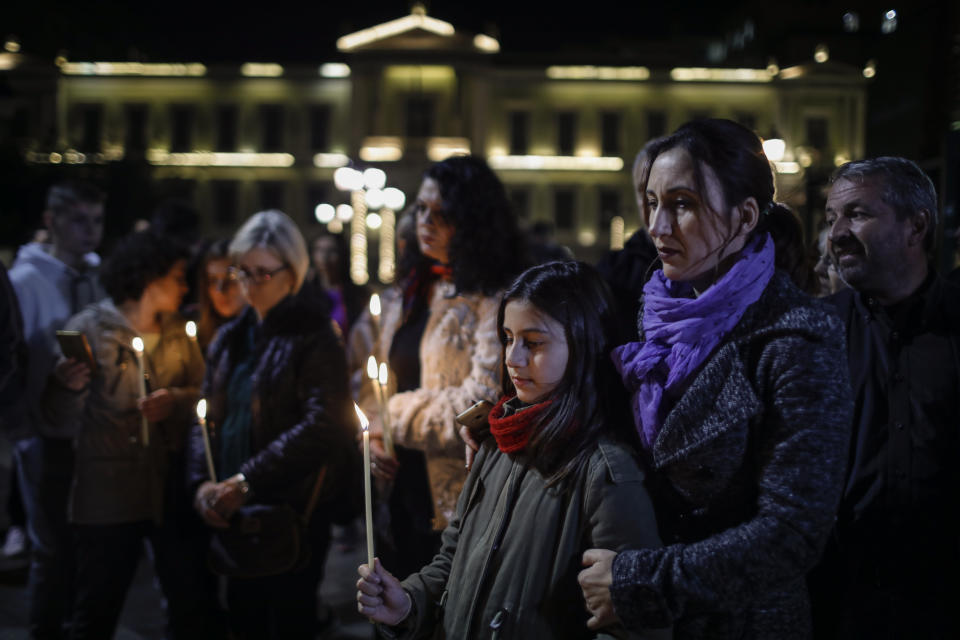Albanian people who live in Greece hold lighted candles, during a memorial in central Athens for the victims of a deadly earthquake that struck Albania a week ago killing at least 51 people, on Tuesday Dec. 3, 2019. (AP Photo/Petros Giannakouris)
