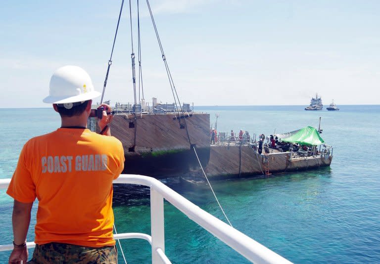 A portion of the stern of the USS Guardian is being lifted by a boat crane, off Palawan island, on March 30, 2013