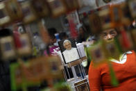 A woman looks at religious articles at a shop in the Basilica of Guadalupe in Mexico City February 11, 2013. Pope Benedict stunned the Roman Catholic Church including his closest advisers on Monday when he announced he would stand down in the first papal abdication in 700 years, saying he no longer had the mental and physical strength to run the Church through a period of major crisis. REUTERS/Edgard Garrido (MEXICO - Tags: RELIGION) - RTR3DNM0