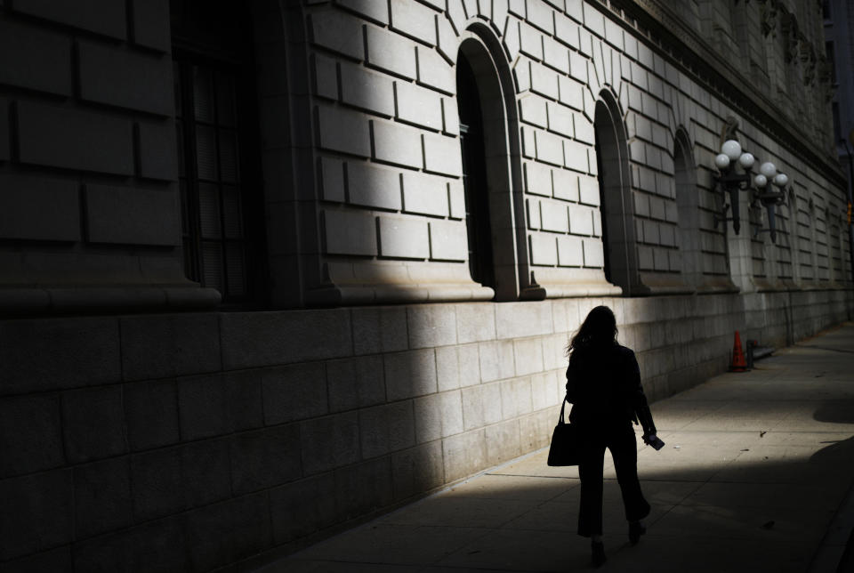 FILE - In this Dec. 3, 2018, file photo a pedestrian is silhouetted against a ray of sunlight hitting a downtown courthouse in Atlanta. Part of being an adult is acknowledging what you learned from your parents, and what you might have to learn for yourself. This is especially true when it comes to managing money (AP Photo/David Goldman, File)