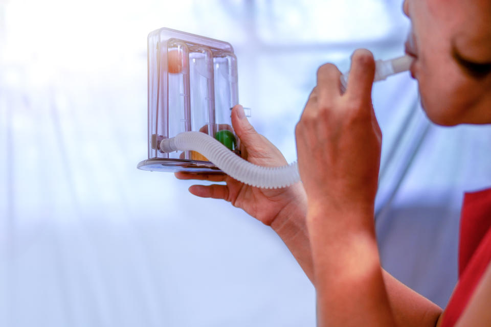 Close-Up Of Woman Using Spirometer