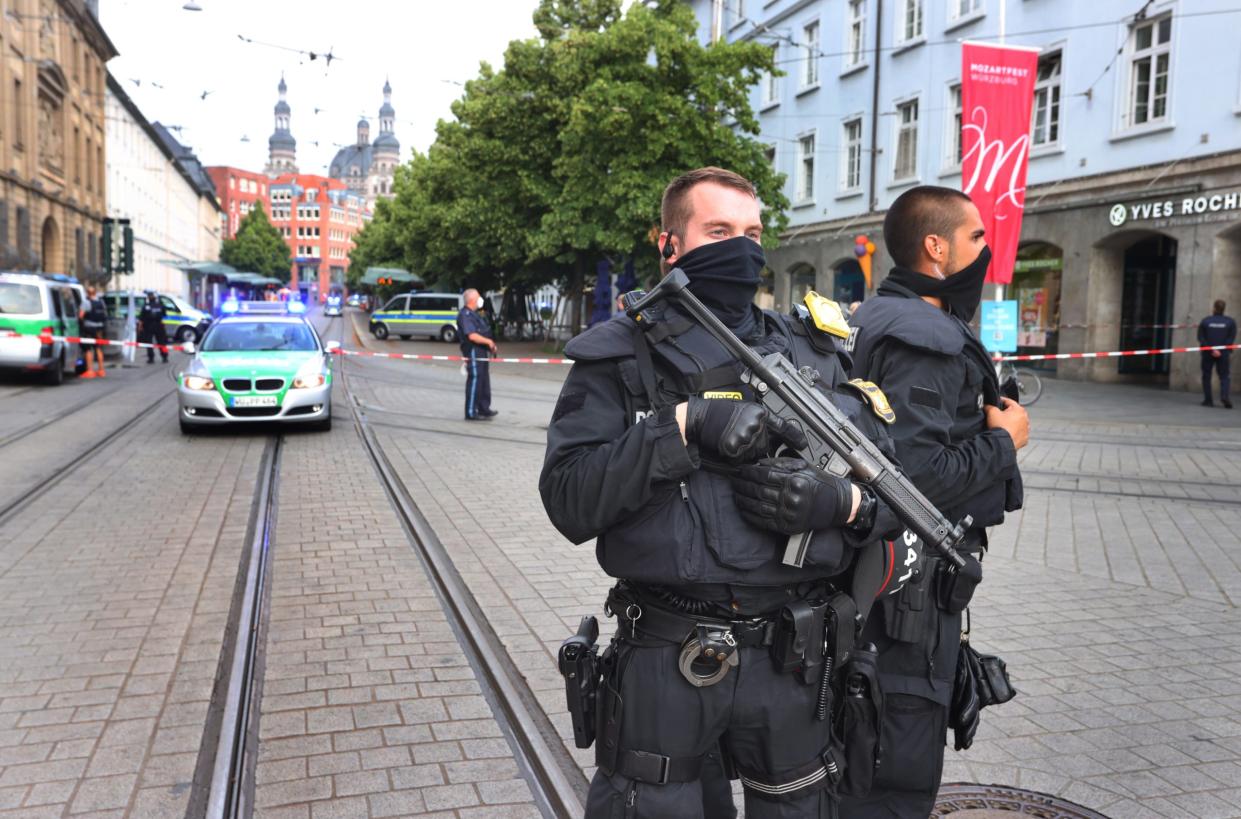 Polizisten stehen in der Innenstadt. Bei einer Messerattacke in der Würzburger Innenstadt sind am Freitag mehrere Menschen getötet worden.