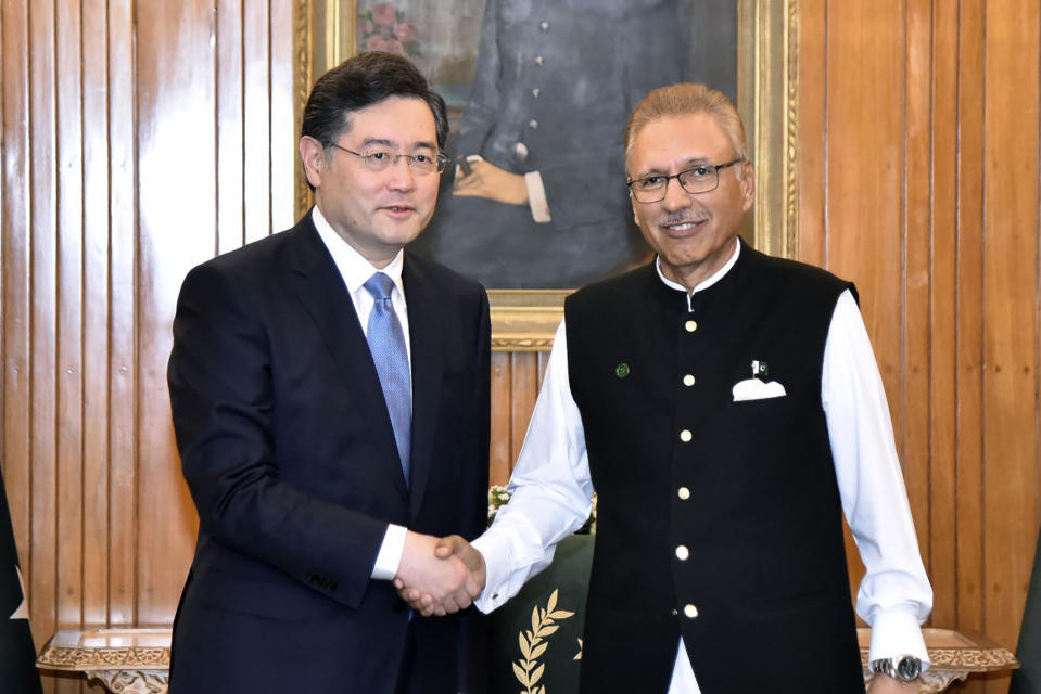 In this photo released by Pakistan's President office, visiting Chinese Foreign Minister Qin Gang, left, shakes hand with Pakistani President Arif Alvi prior to their meeting, in Islamabad, Pakistan, Friday, May 5, 2023. The Pakistani president on Friday assured Beijing's top diplomat that his country will boost security for all Chinese nationals working on multi-billion dollar projects in cash-strapped Pakistan. (Pakistan President Office via AP)