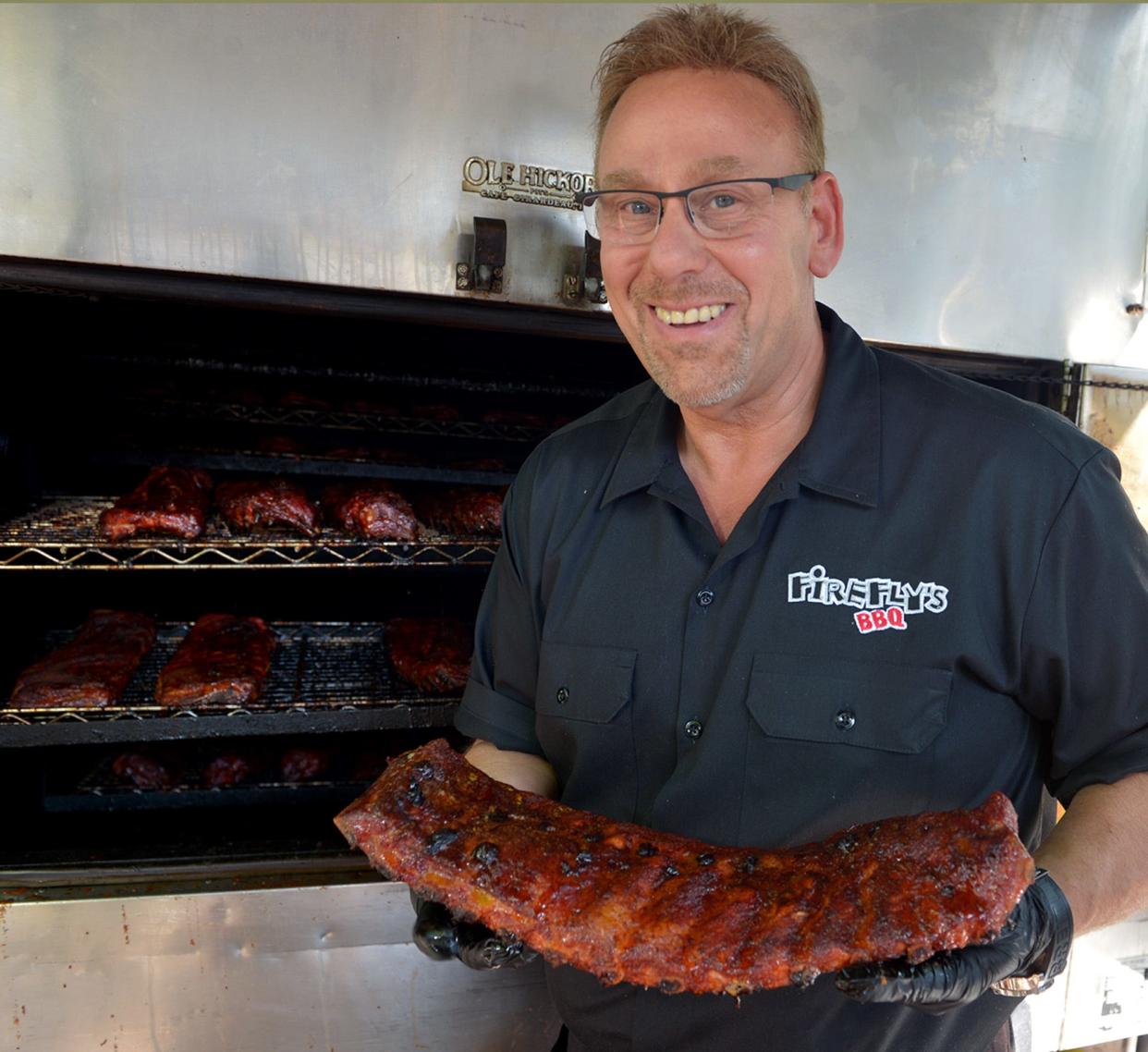 Steve Uliss, shown holding a rack of ribs from the outdoor smoker last year, owns Firefly's BBQ in Marlborough.