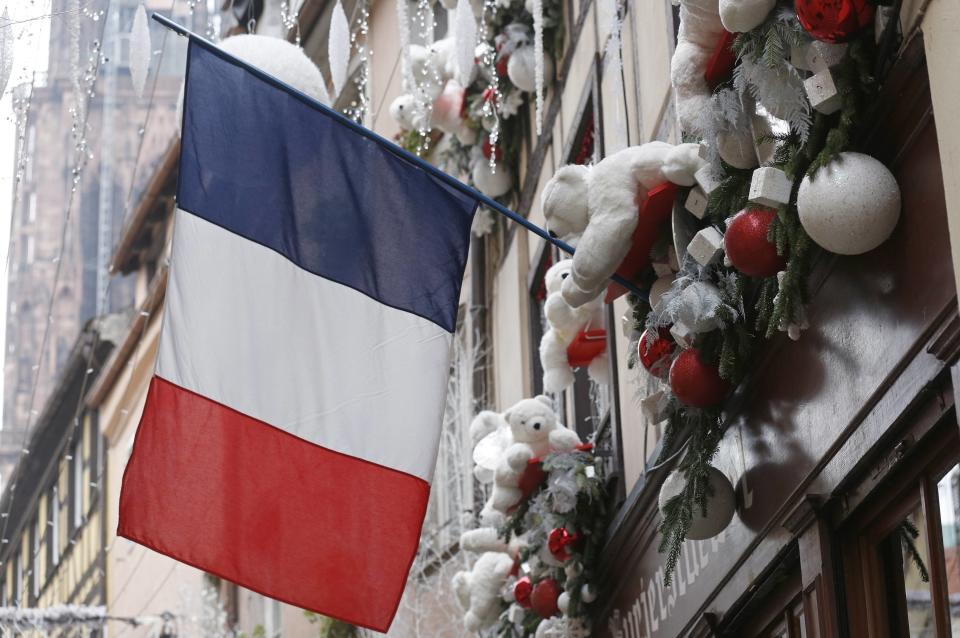 A French flag hangs from a window of a restaurant decorated for Christmas holiday season in Strasbourg, France, November 27, 2015 after the French President called on all French citizens to hang the tricolour national flag from their windows to pay tribute to the victims of the Paris attacks during a national day of homage. (REUTERS/Vincent Kessler)