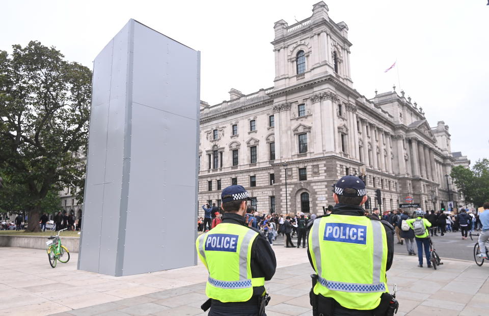 Black lives matter protesters march by a covered statue of Winston Churchill in London. Source: EPA