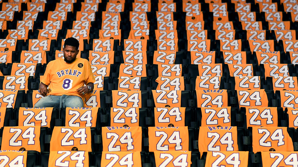 Usher, pictured here sitting alone in the stands at Staples Centre before his performance.