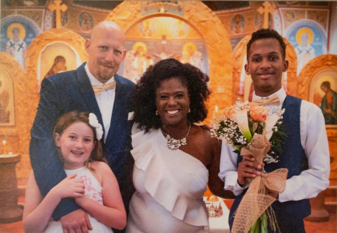 A framed wedding photo of Matthew and LaKiesha Moore with their children hangs in their home on Kansas City’s East Side. The couple met at a Black community event in New Mexico.