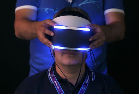 A visitor tries Sony's "Project Morpheus" VR headset at an exhibition stand during the Gamescom 2014 fair in Cologne August 13, 2014. REUTERS/Ina Fassbender