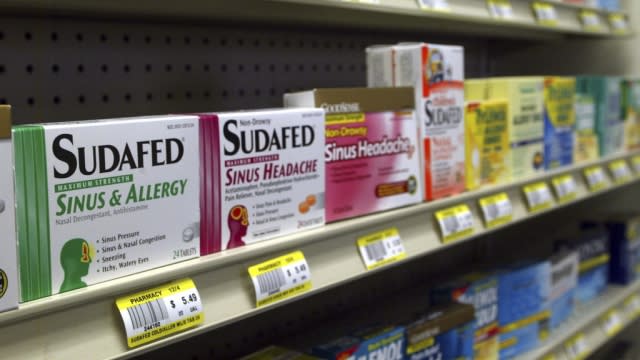 Sudafed pills are shown on a grocery store shelf.