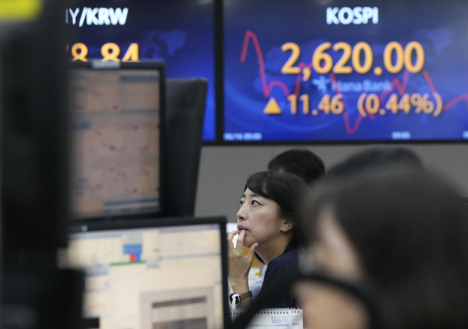 A currency trader watches monitors near the screens showing the Korea Composite Stock Price Index (KOSPI), top right, at the foreign exchange dealing room of the KEB Hana Bank headquarters in Seoul, South Korea, Friday, June 16, 2023. Asian shares logged moderate gains on Friday after Wall Street benchmarks swept higher, extending their longest rally in a year and a half. (AP Photo/Ahn Young-joon)