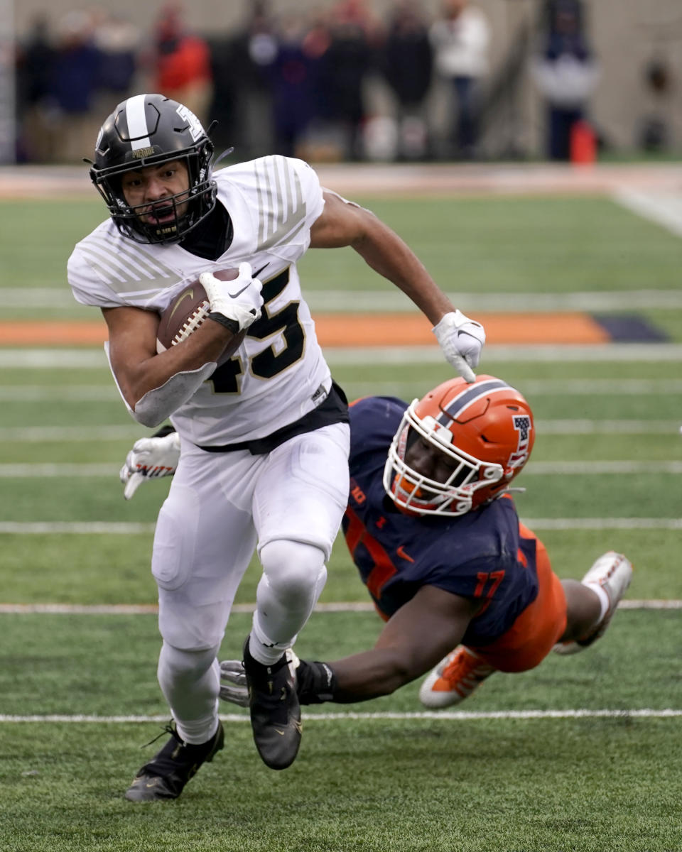 Purdue running back Devin Mockobee runs away from Illinois linebacker Gabe Jacas during the first half of an NCAA college football game Saturday, Nov. 12, 2022, in Champaign, Ill. (AP Photo/Charles Rex Arbogast)