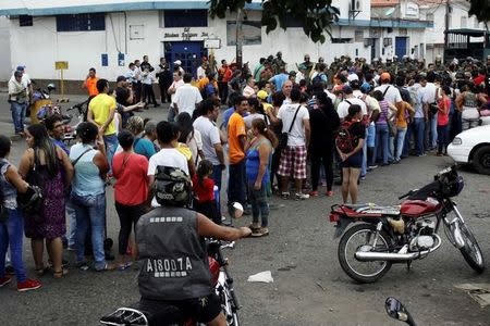 People make a line in front of Venezuelan National Guards as they wait to try to cross the border to Colombia over the Francisco de Paula Santander international bridge in Urena, Venezuela December 18, 2016. REUTERS/Carlos Eduardo Ramirez