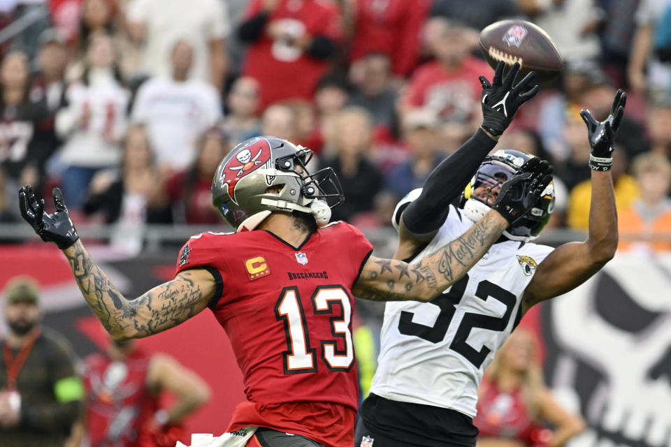 Jacksonville Jaguars cornerback Tyson Campbell (32) breaks up a pass intended for Tampa Bay Buccaneers wide receiver Mike Evans (13) during the first half of an NFL football game Sunday, Dec. 24, 2023, in Tampa, Fla. (AP Photo/Jason Behnken)