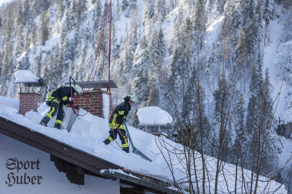 Firefighters clear the snow from a roof in Bayrischzell, Germany, Wednesday, Jan. 16, 2019. (Christoph Reichwein/dpa via AP)