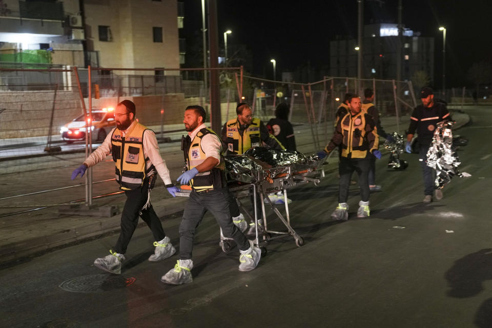 Members of Zaka Rescue and Recovery team evacuate a body after a shooting attack near a synagogue in Jerusalem , Friday, Jan. 27, 2023. A Palestinian gunman opened fire outside an east Jerusalem synagogue Friday night, killing five people and wounding five others in one of the deadliest attacks on Israelis in years, medical officials said. The attack was halted when the gunman was shot by police. (AP Photo/Mahmoud Illean)