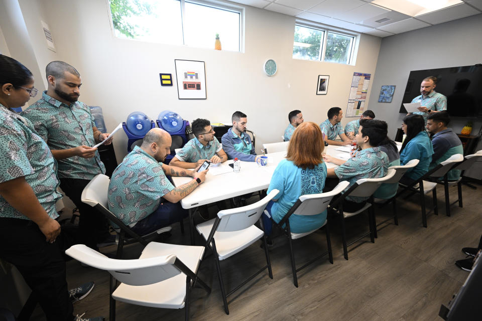 Members of the Pineapple Healthcare medical clinic attend a staff meeting before opening for the day in Orlando, Fla., on May 28, 2024. (AP Photo/Phelan M. Ebenhack)