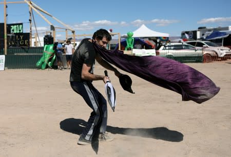 A man dances as an influx of tourists responding to a call to 'storm' Area 51, a secretive U.S. military base believed by UFO enthusiasts to hold government secrets about extra-terrestrials, is expected in Rachel, Nevada