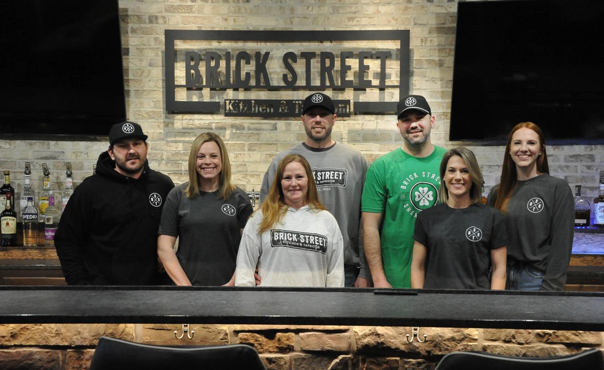 The team at Brick Street Kitchen & Taproom in Orrville - Aaron Green, left, Hale Green, Nicole Lacy, Brian Lacy, Joel Beichler, Amber Beichler and Hillary Plybon - are ready for Saturday's opening, which will include live music by the band Basement Bromance.