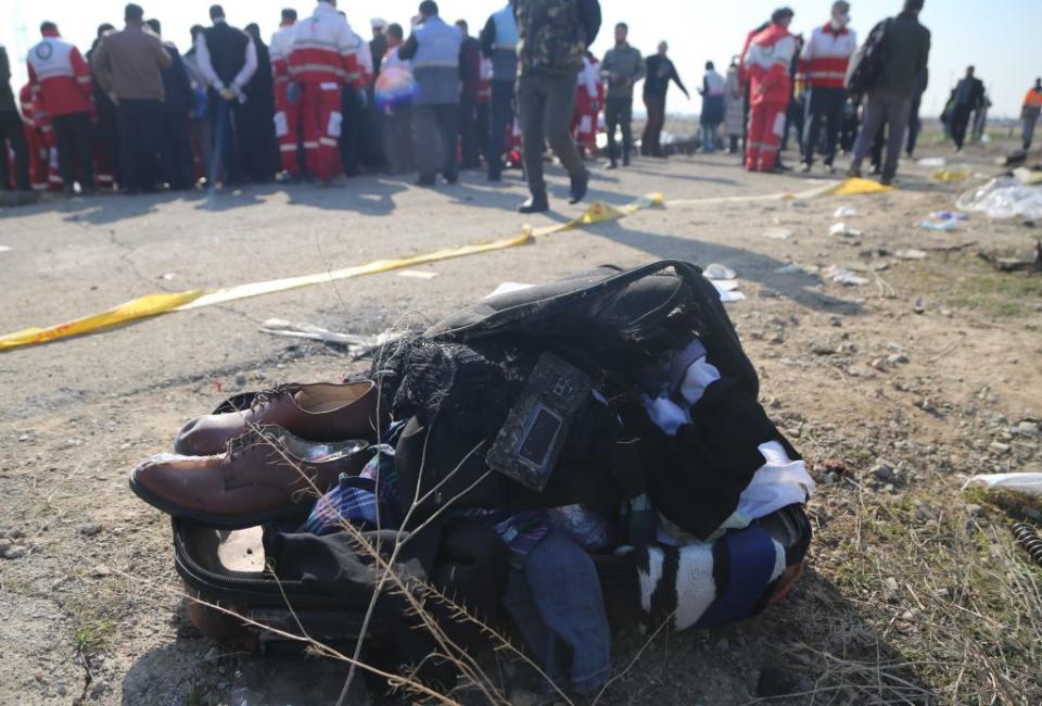 Belongings of passengers are brought from the site by search and rescue team members. Source: Getty