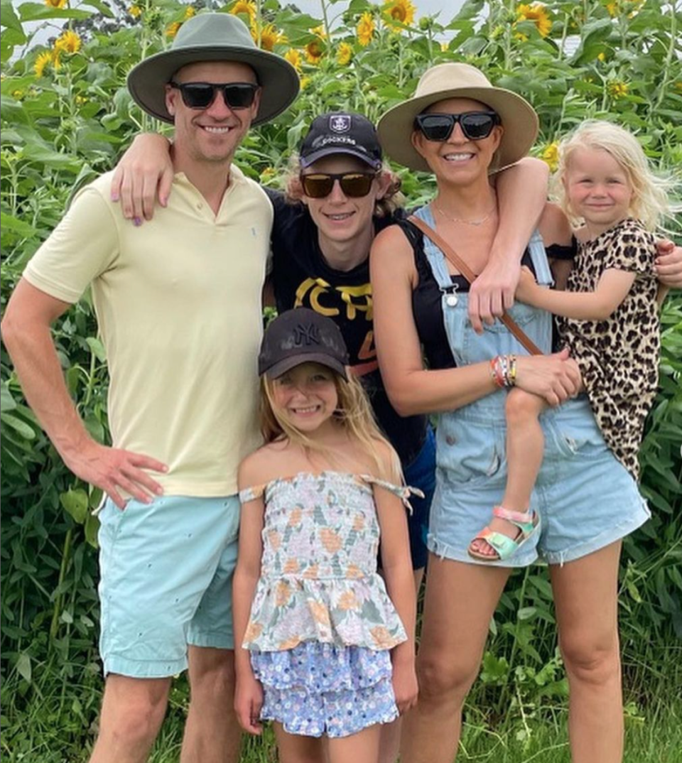 Carrie Bickmore pictured with her husband Chris, and kids Oliver, Evie and Adelaide in a sunflower field