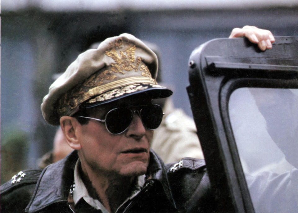 Laurence Olivier dons aviator sunglasses and a general's hat