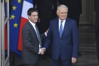 Outgoing French Prime Minister Jean-Marc Ayrault, right, shakes hands with incoming French Prime Minister Manuel Valls, during the takeover ceremony at the Prime Ministry in Paris, Tuesday, April 1, 2014. France's new prime minister is taking office after Socialist President Francois Hollande named Valls on Monday as prime minister. (AP Photo/Lionel Bonaventure, Pool)