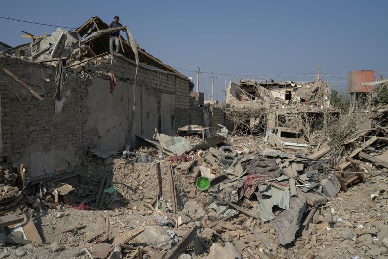 Ali Ibrahimov works on the ruins of his home, which was hit by a rocket, in the city of Ganja