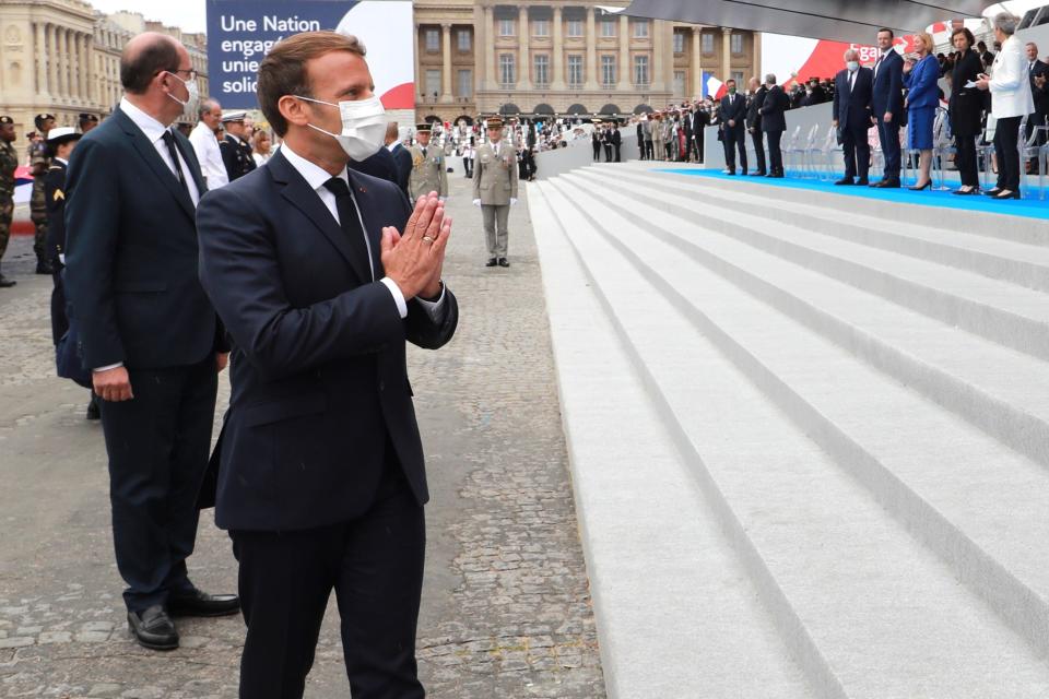 TOPSHOT - French President Emmanuel Macron greets visitors after Paris' traditional Bastille Day parade, which was scaled back this year due to COVID-19.