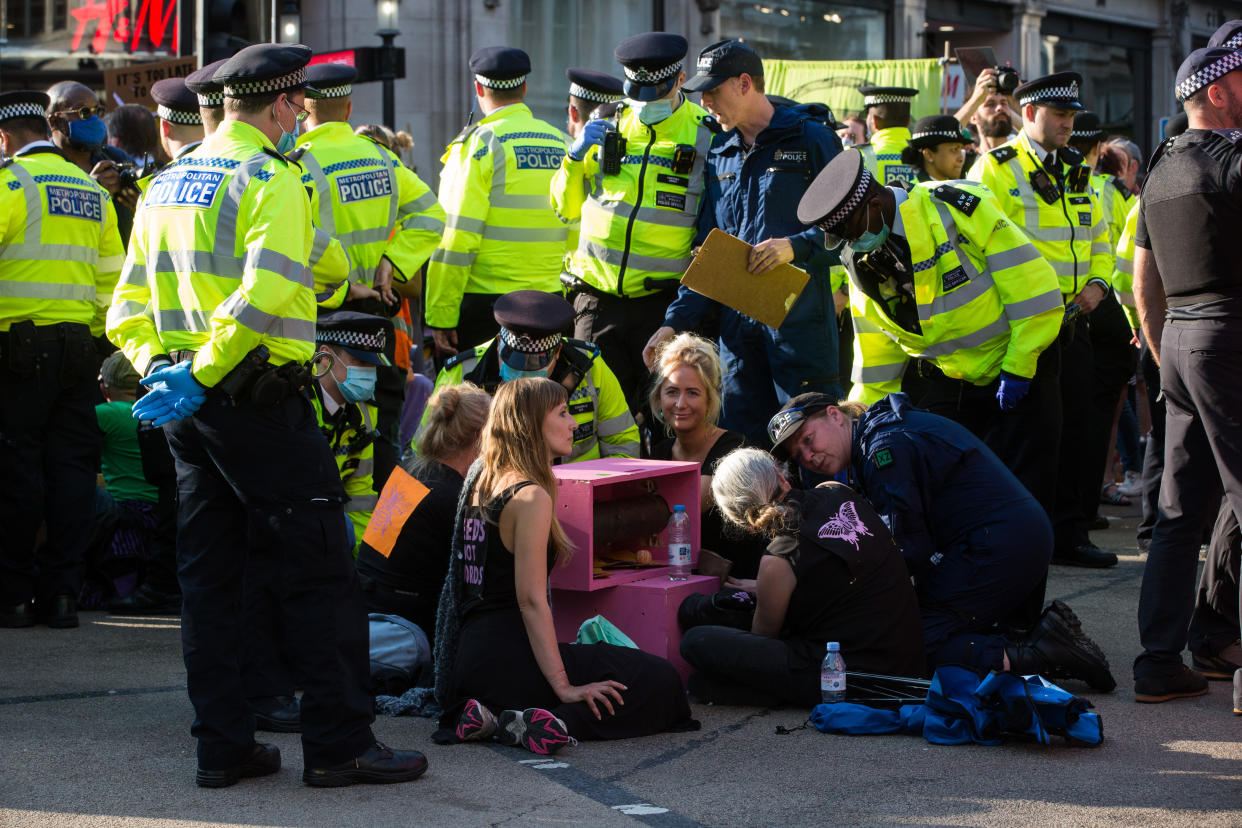 Metropolitan and other police officers prepare to remove and arrest Extinction Rebellion activists who had taken part in a pink roadblock of Oxford Circus by women and FINT-identifying environmental activists during the third day of Impossible Rebellion protests on 25th August 2021 in London, United Kingdom. Extinction Rebellion are calling on the UK government to cease all new fossil fuel investment with immediate effect. (photo by Mark Kerrison/In Pictures via Getty Images)