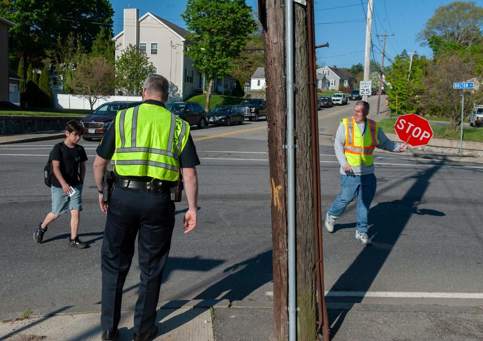 Police help students on their way to school cross Bolton St. as bus drivers on strike picketed outside the Whitcomb Middle School andf the high school  in Marlborough, May 8, 2023.