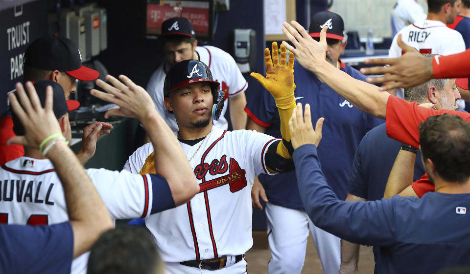 Atlanta Braves' William Contreras gets high-fives in the dugout hitting a two-run home run against the St. Louis Cardinals during the first inning of a baseball game Tuesday, July 5, 2022, in Atlanta. (Curtis Compton/Atlanta Journal-Constitution via AP)