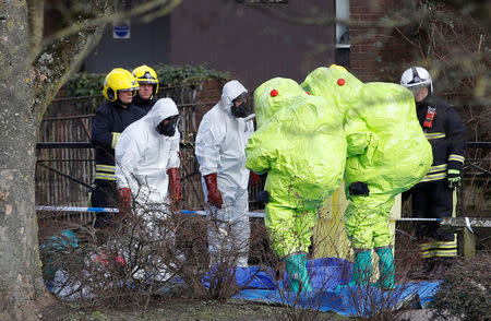 Officials in protective suits check their equipment before repositioning the forensic tent, covering the bench where Sergei Skripal and his daughter Yulia were found, in the centre of Salisbury, Britain, March 8, 2018. REUTERS/Peter Nicholls