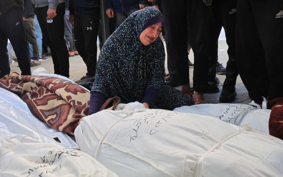 A woman mourns over the bodies of family members killed during Israeli bombardment overnight, at Nasser hospital in Rafah