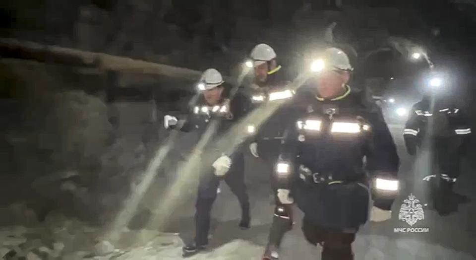 In this photo taken from video released by Russia Emergency Situations Ministry press service on Friday, March 22, 2024, Russia Emergency Situations employees walk inside the gold mine in Zeysk district, Amur region, eastern Russia. Rescue workers are laboring for a fifth day to reach 13 people trapped deep underground in a collapsed gold mine in Russia's far east. News reports say no contact has been made with the miners in the Amur region, about 5,000 kilometers (3,000 miles) east of Moscow. (Russia Emergency Situations Ministry press service via AP)