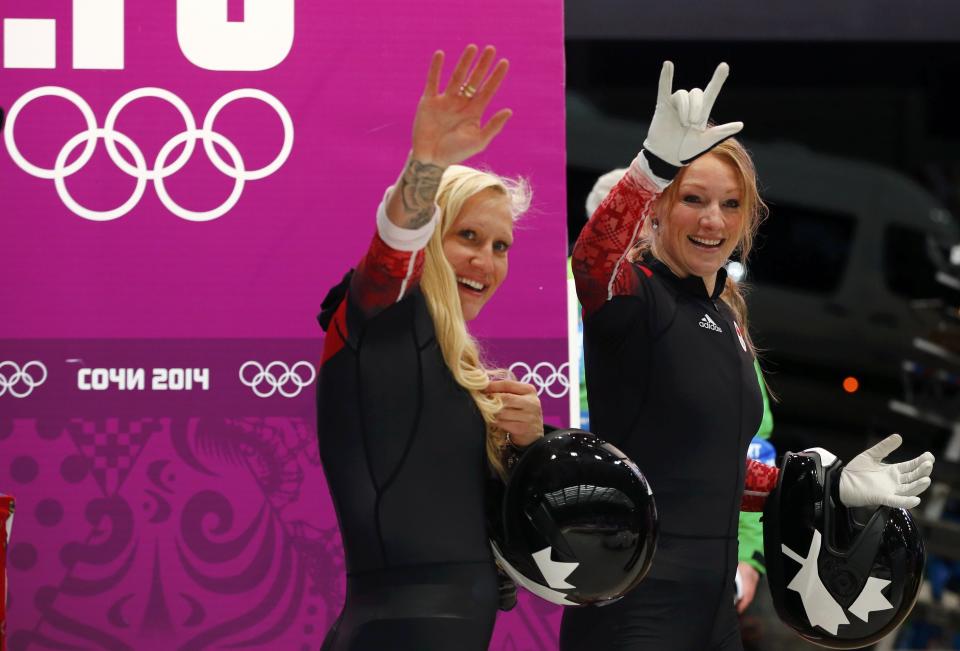 Canada's pilot Kaillie Humphries (L) and teammate Heather Moyse wave to fans after completing a run in the women's bobsleigh event at the 2014 Sochi Winter Olympics, at the Sanki Sliding Center in Rosa Khutor February 19, 2014. REUTERS/Arnd Wiegmann (RUSSIA - Tags: SPORT BOBSLEIGH OLYMPICS)