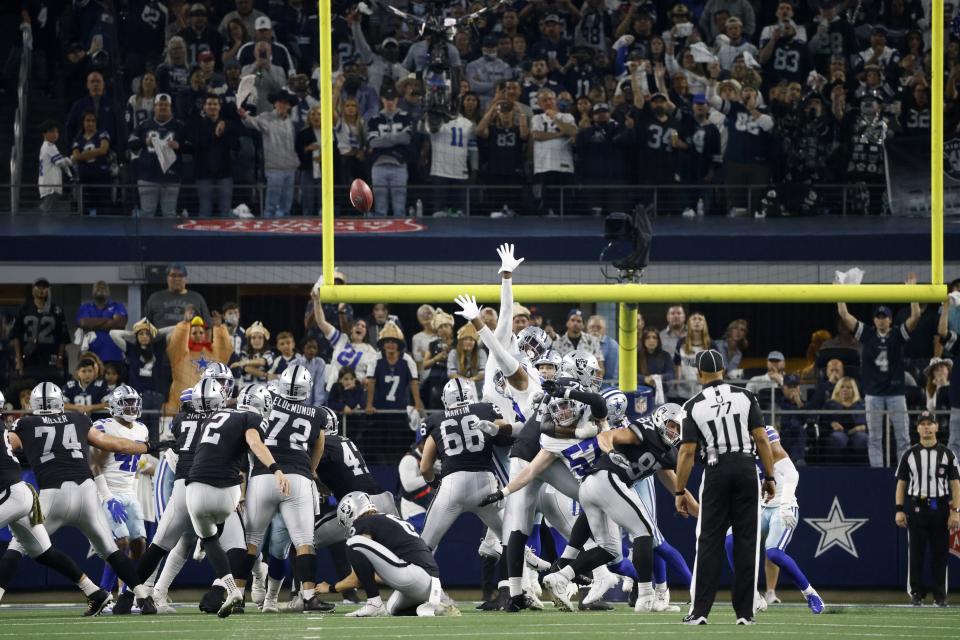 Fans look on as Las Vegas Raiders' Daniel Carlson (2) kicks a game-winning field goal in overtime of an NFL football game against the Dallas Cowboys in Arlington, Texas, Thursday, Nov. 25, 2021. (AP Photo/Ron Jenkins)