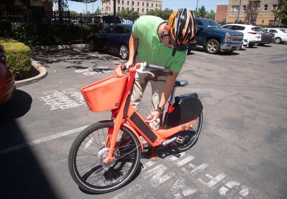 Stockton Mobility Collective assistant planner Jay Halva demonstrates an electric assisted bike at the San Joaquin Council of Governments office in downtown Stockton.
