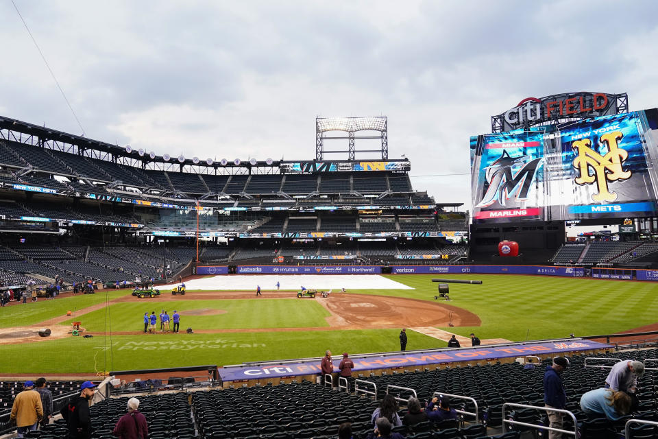 Fans watch the grounds crew work on the field before a baseball game between the Miami Marlins and the New York Mets, Tuesday, Sept. 26, 2023, at Citi Field in New York. (AP Photo/Frank Franklin II)