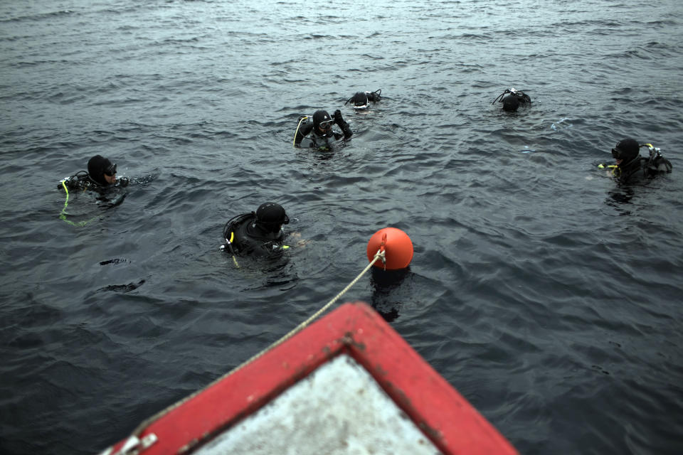 CAPTION CORRECTS THE PHOTOGRAPHER - In this photo taken on Sunday, April 7, 2019, archeologists and visitors prepare to dive to a 5th Century B.C. shipwreck, the first ancient shipwreck to be opened to the public in Greece, including to recreational divers who will be able to visit the wreck itself, near the coast of Peristera, Greece. Greece’s rich underwater heritage has long been hidden from view, off-limits to all but a select few, mainly archaeologists. Scuba diving was banned throughout the country except in a few specific locations until 2005, for fear that divers might loot the countless antiquities that still lie scattered on the country’s seabed. Now that seems to be gradually changing, with a new project to create underwater museums. (AP Photo/Petros Giannakouris)