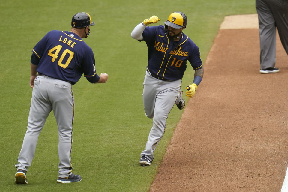 Milwaukee Brewers' Omar Narvaez reacts with third base coach Jason Lane (40) after hitting a two-run home run during the sixth inning of a baseball game against the San Diego Padres, Wednesday, April 21, 2021, in San Diego. (AP Photo/Gregory Bull)