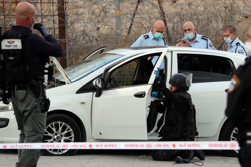 Israeli security forces survey a car at the scene of what Israeli police said was an attempted car-ramming attack at a checkpoint in East Jerusalem