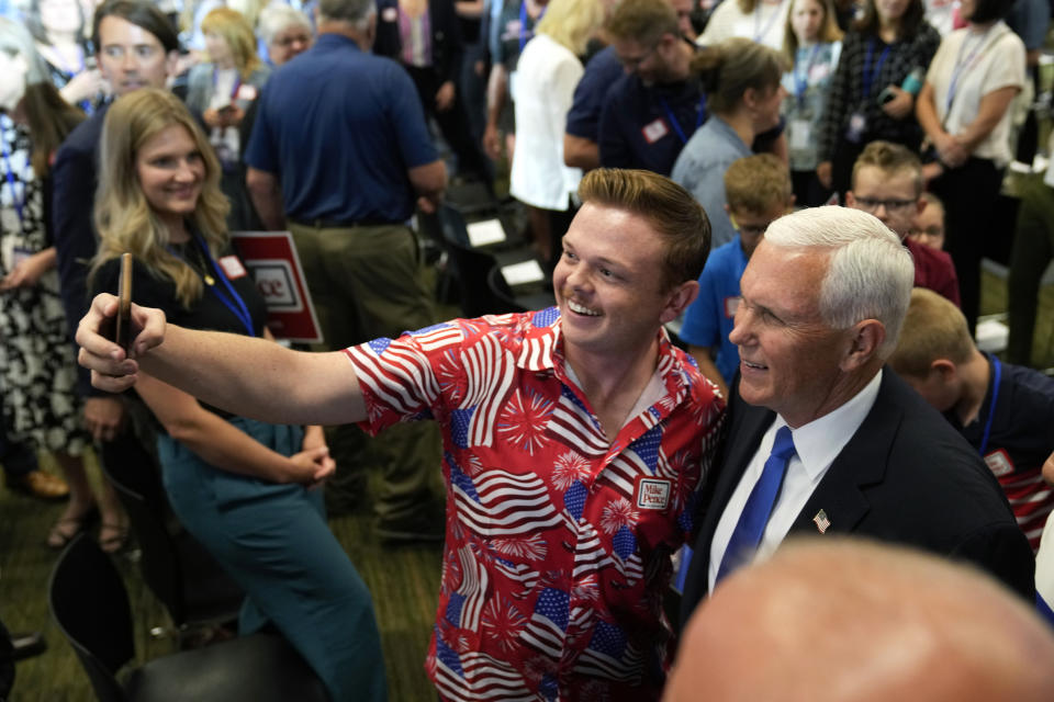 Republican presidential candidate former Vice President Mike Pence poses for a photo with an audience member at a campaign event, Wednesday, June 7, 2023, in Ankeny, Iowa. (AP Photo/Charlie Neibergall)