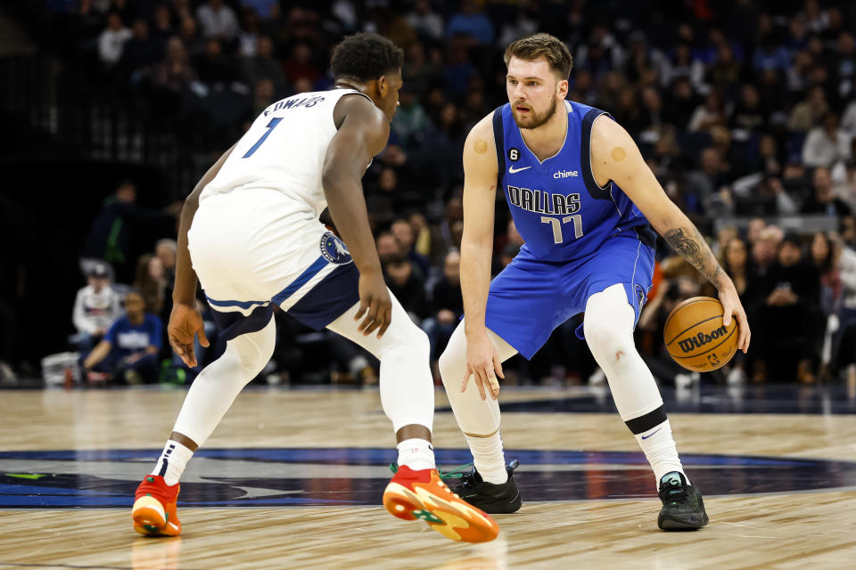 MINNEAPOLIS, MN - DECEMBER 19: Luka Doncic #77 of the Dallas Mavericks dribbles the ball as Anthony Edwards #1 of the Minnesota Timberwolves defends during the first quarter of the game at Target Center on December 19, 2022 in Minneapolis, Minnesota. The Timberwolves defeated the Mavericks 116-106. NOTE TO USER: User expressly acknowledges and agrees that by downloading and/or using this photograph, user agrees to the terms of the Getty Images License Agreement. (Photo by David Berding/Getty Images)