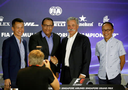 Formula One chief, Chase Carey, shakes hands with Singapore's Trade and Industry Minister S. Iswaran during a news conference at the Singapore F1 Grand Prix night race in Singapore September 15, 2017. REUTERS/Edgar Su