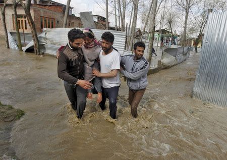 A woman is carried to a safer place from her partially submerged house after incessant rains in Srinagar March 30, 2015. REUTERS/Danish Ismail