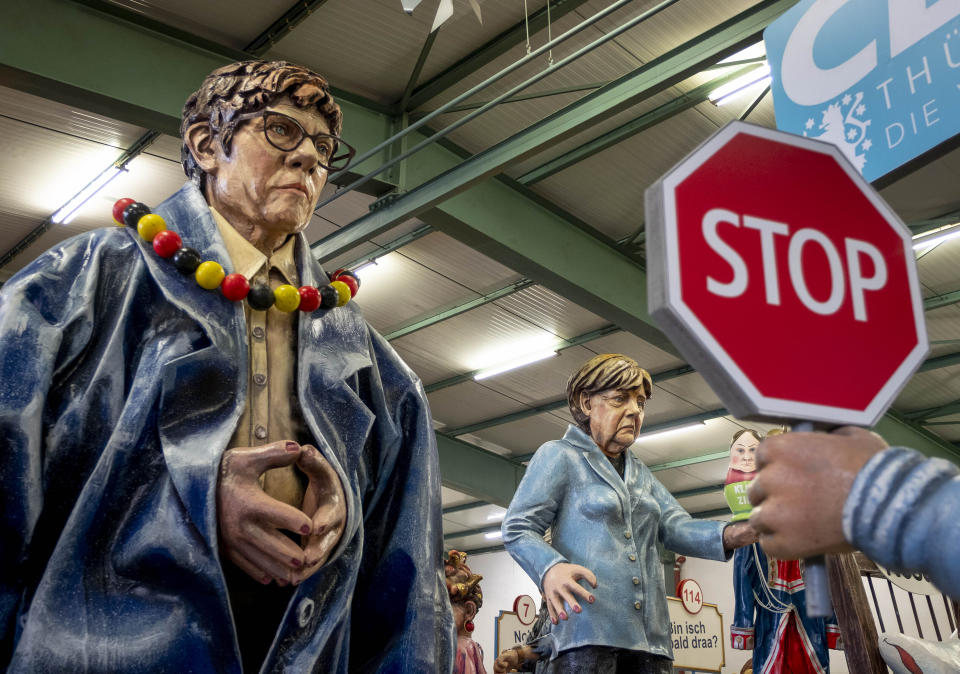 Figures depicting German Chancellor Angela Merkel, right, and CDU leader Annegret Krampp-Karrenbauer are shown during a press preview for the Mainz carnival, in Mainz, Germany, Tuesday, Feb. 18, 2020. (AP Photo/Michael Probst)