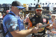 Martin Truex Jr. signs autographs as he enters the garage for a NASCAR Cup Series auto race practice at Homestead-Miami Speedway in Homestead, Fla., Saturday, Nov. 16, 2019. (AP Photo/Luis M. Alvarez)