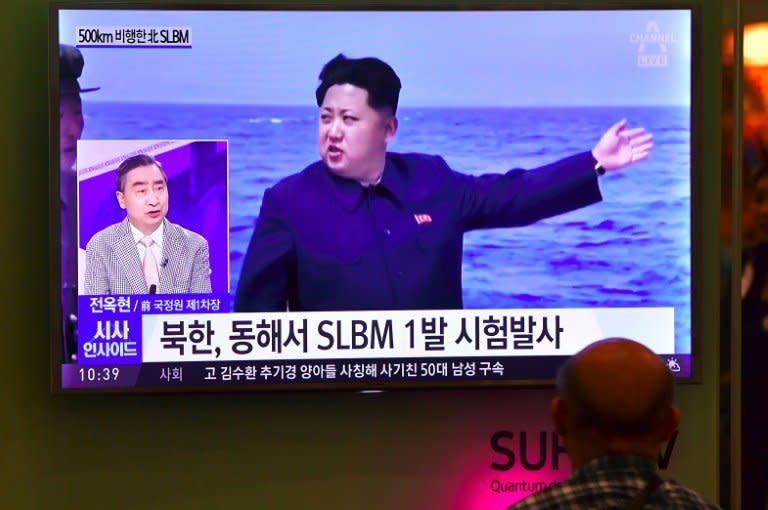 People in Seoul watch a TV broadcast showing North Korea's leader Kim Jong-Un during a missile launch on August 24, 2016