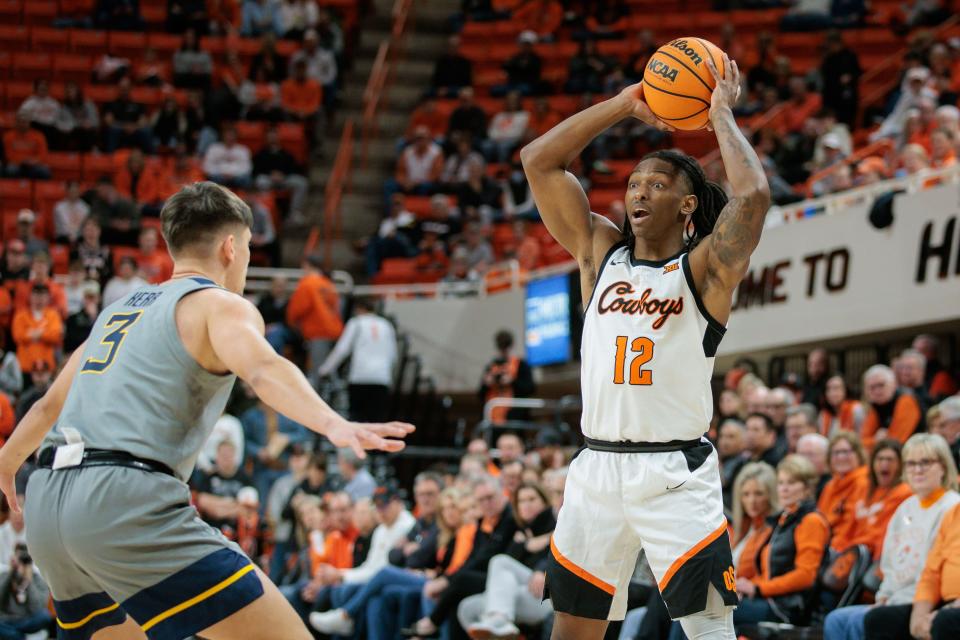 Jan 27, 2024; Stillwater, Oklahoma, USA; Oklahoma State Cowboys guard Javon Small (12) controls the ball against West Virginia Mountaineers guard Kerr Kriisa (3) during the first half at Gallagher-Iba Arena. Mandatory Credit: William Purnell-USA TODAY Sports